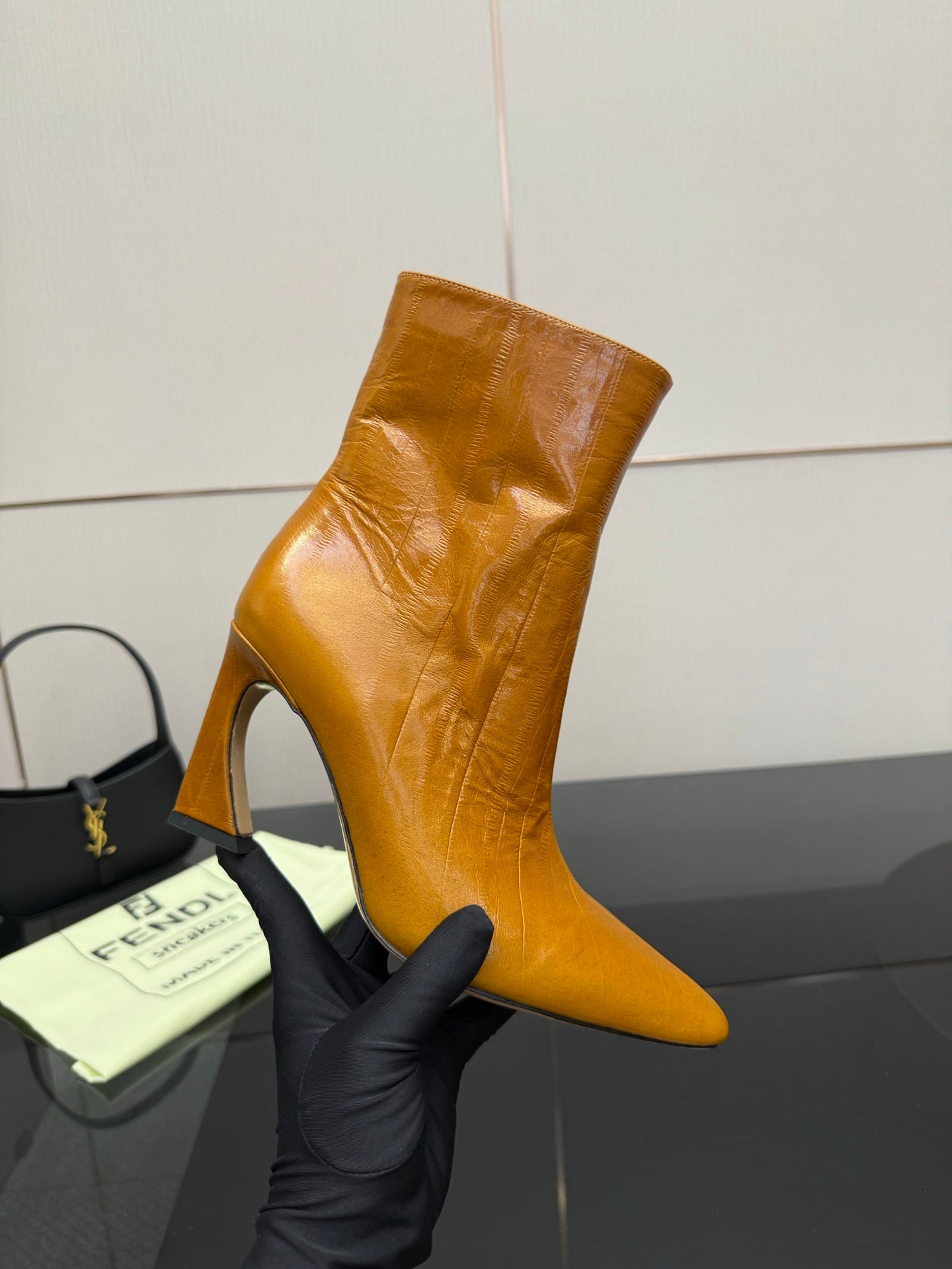 Tan leather ankle boot with high heel, pointed toe, and side zipper