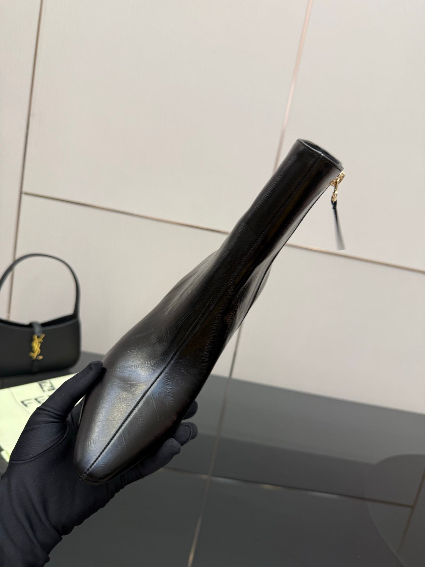 Women’s black leather ankle boot with pointed toe and high heel, side angle