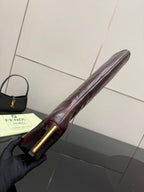 Knee-high boot side view, dark burgundy leather with pointed toe and gold accent heel