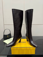 Pair of dark leather knee-high boots with block heels and smooth pointed toes