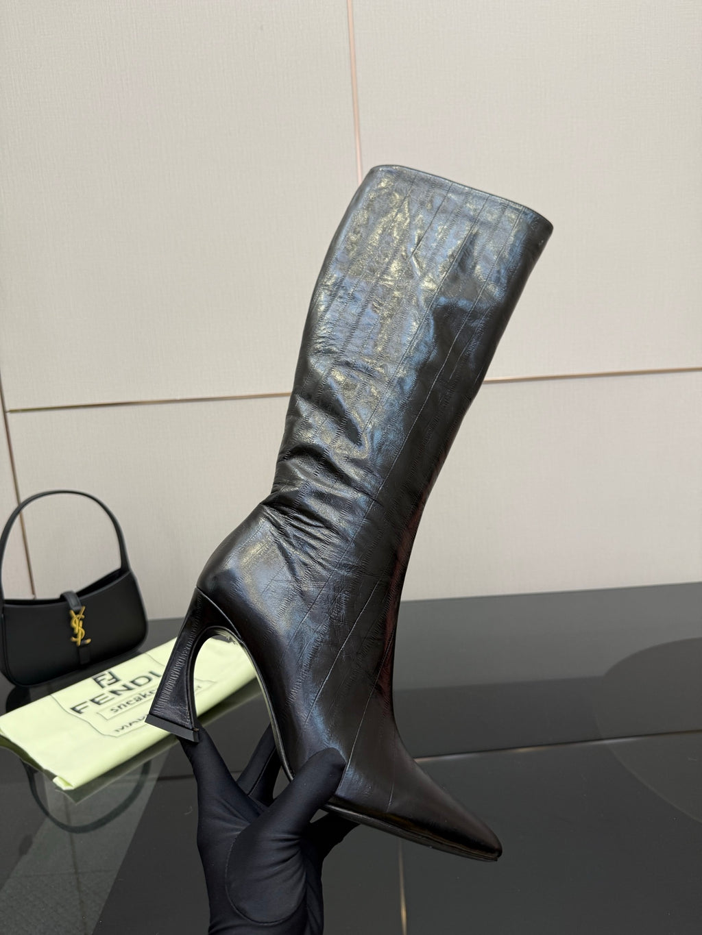 Dark knee-high heeled boot with tall stiletto heel and smooth leather upper