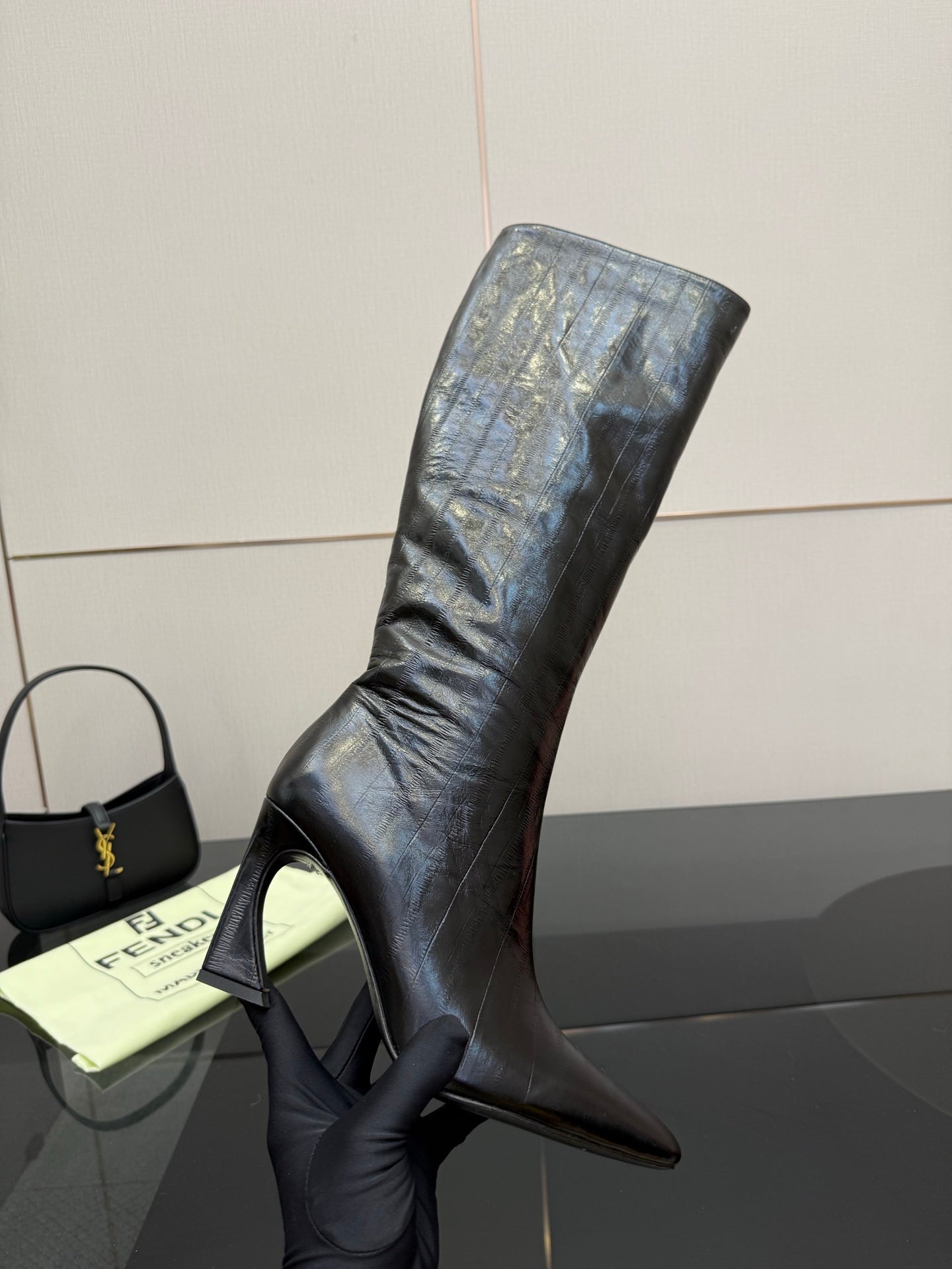 Dark knee-high heeled boot with tall stiletto heel and smooth leather upper