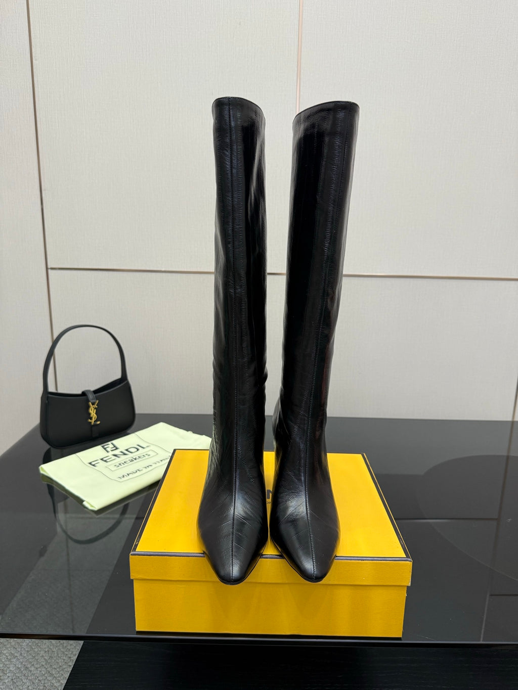 Pair of dark knee-high heeled boots with slim stiletto heel