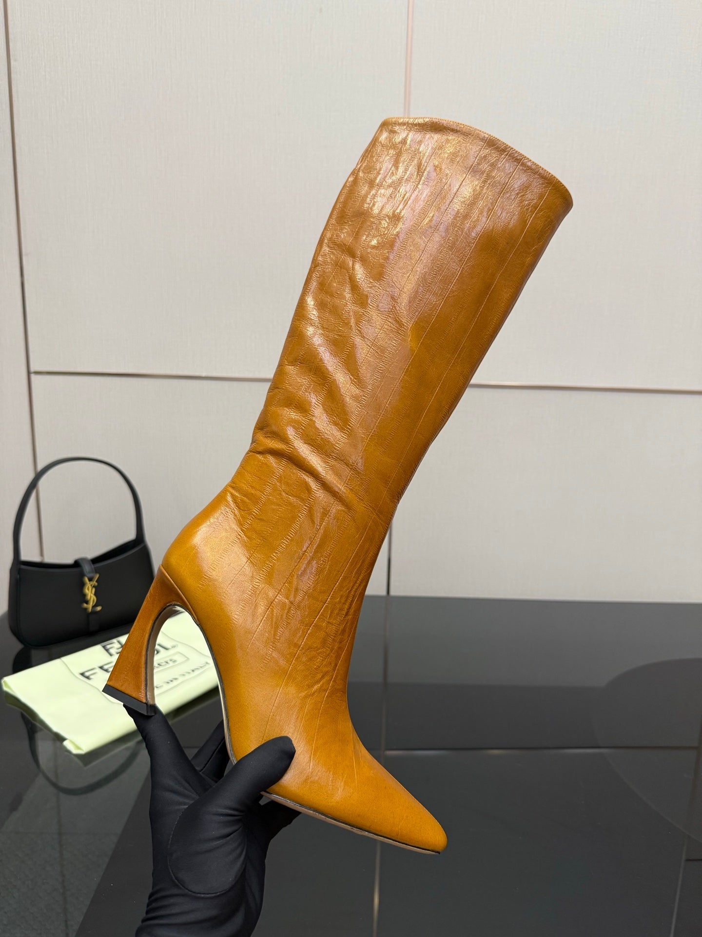 Fendi women’s knee-high leather boots, tan, angled view with narrow stiletto heel.