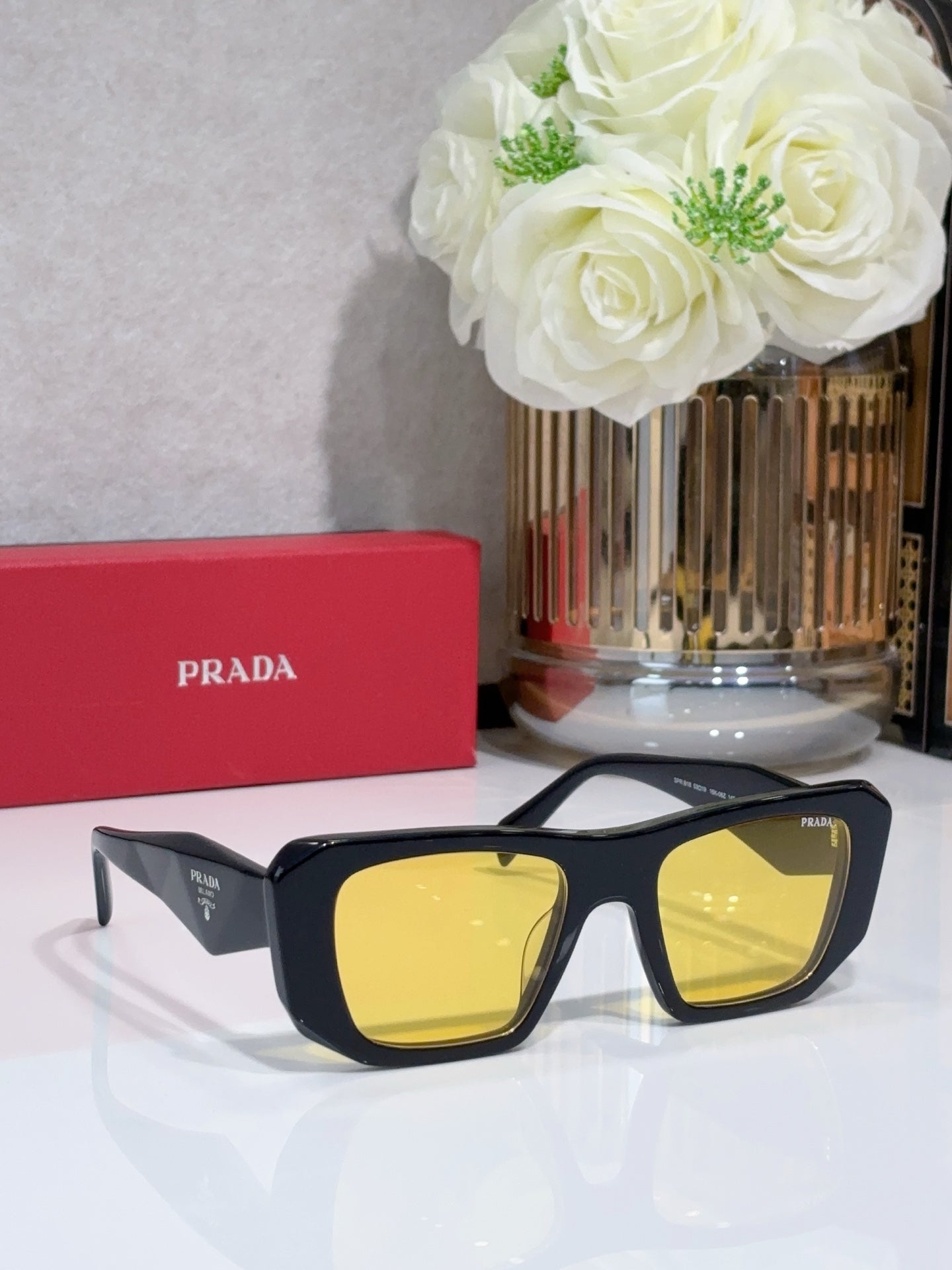 Prada sunglasses with black frame and yellow tinted lenses