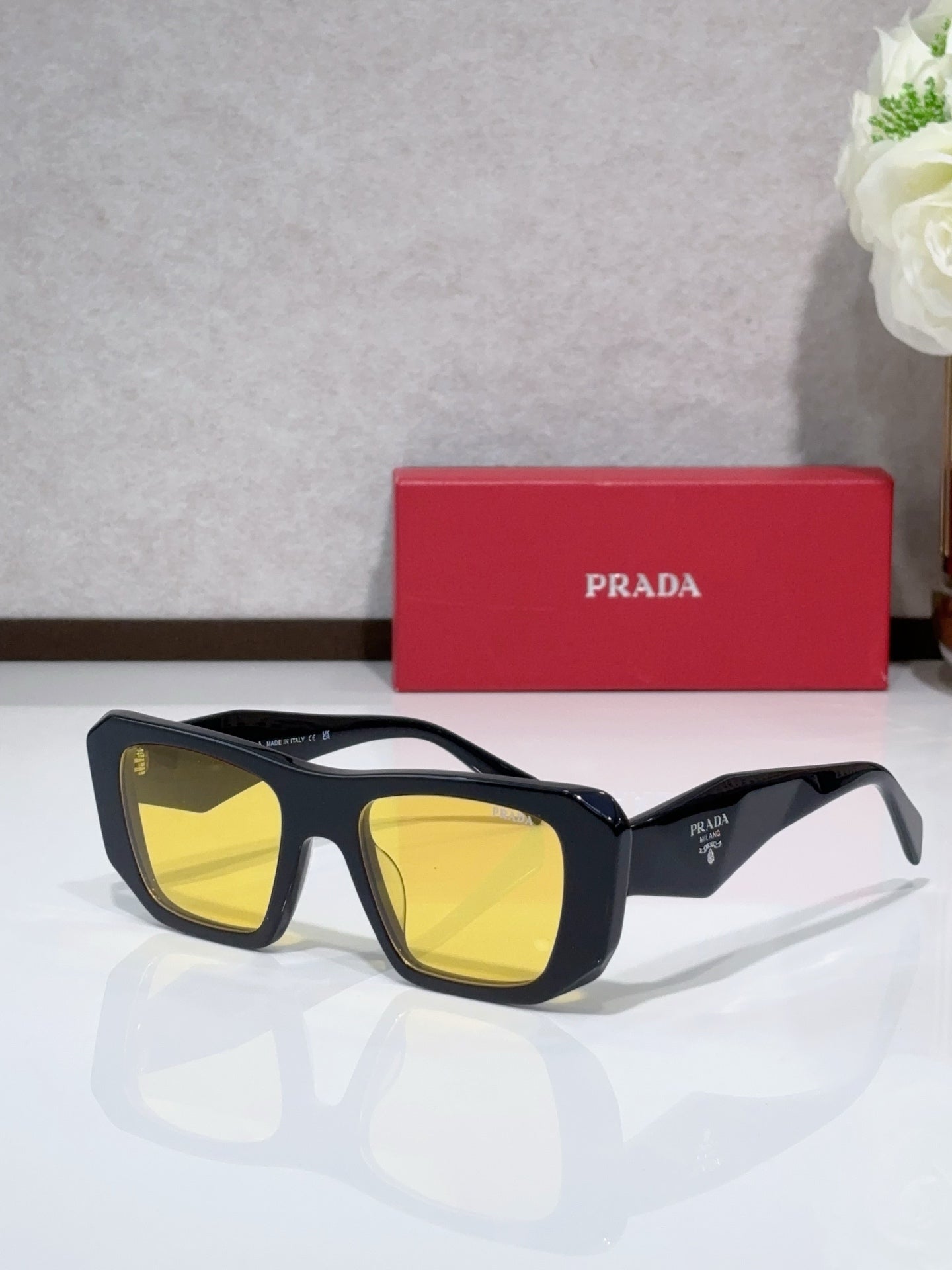 Prada sunglasses with black frame and yellow tinted lenses