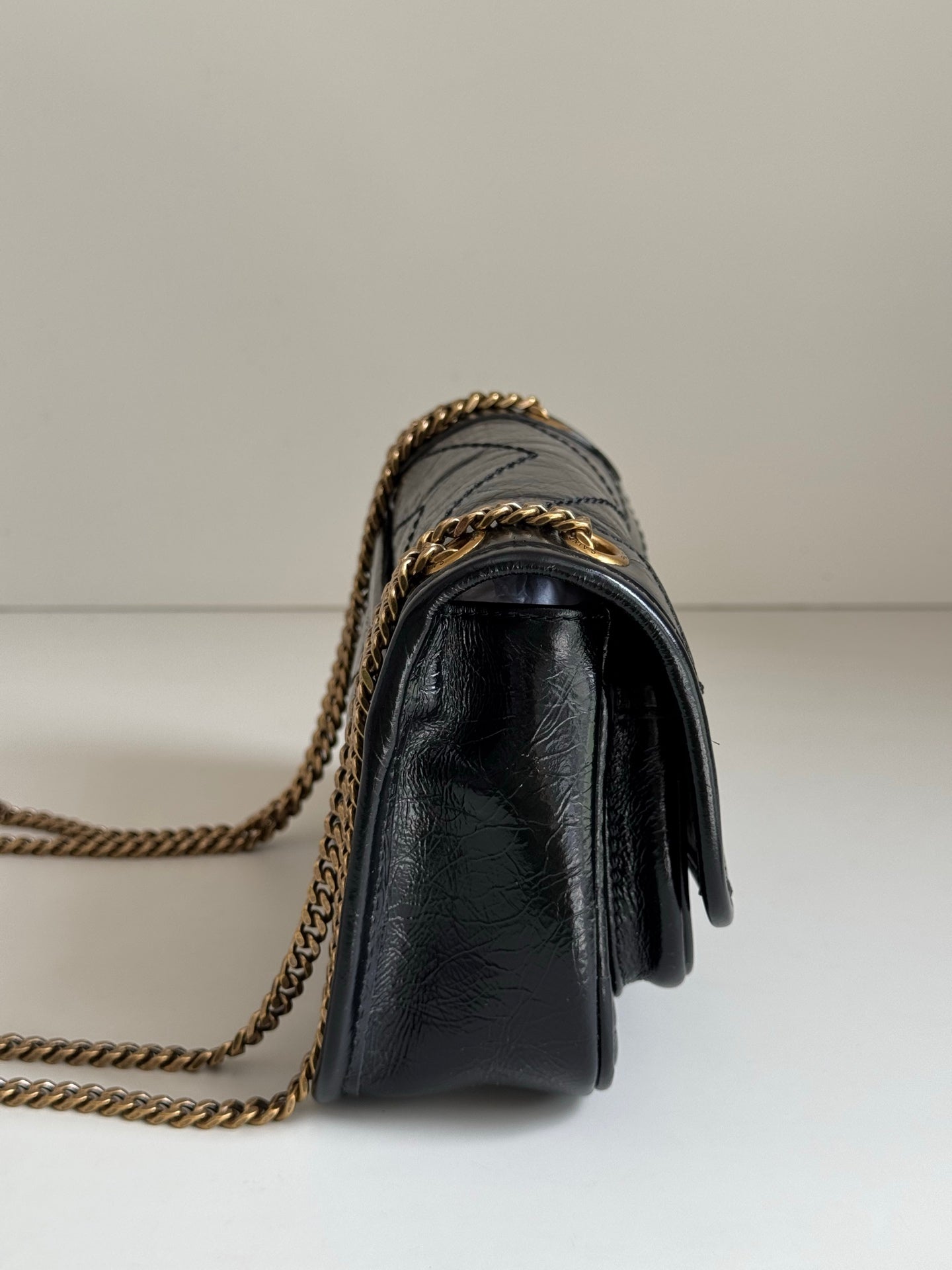 YSL dark leather crossbody bag with gold chain strap and flap front