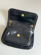 YSL dark leather mini bag with fold-over flap, front pocket and gold buttons