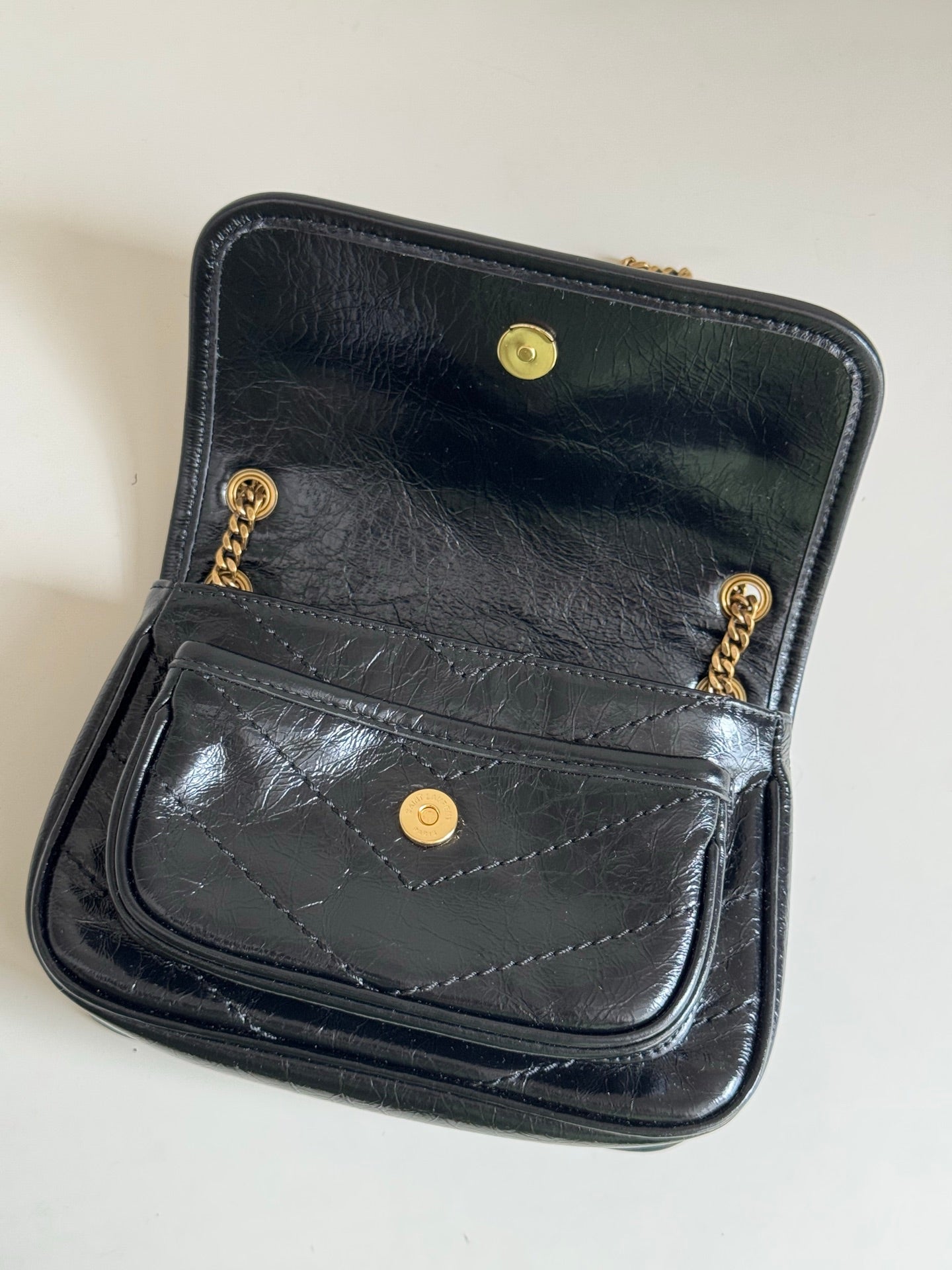 YSL dark leather mini bag with fold-over flap, front pocket and gold buttons