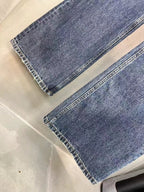 Balenciaga denim pants hems detail, faded blue wash with visible stitching