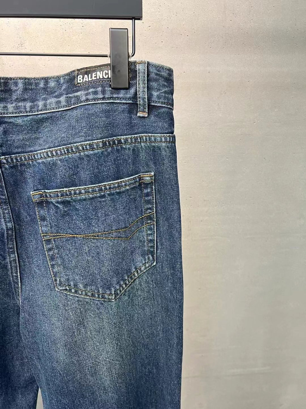 Balenciaga denim pants back view, medium blue wash, flap-style back pocket and logo tab