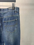 Balenciaga denim pants back view, medium blue wash, flap-style back pocket and logo tab