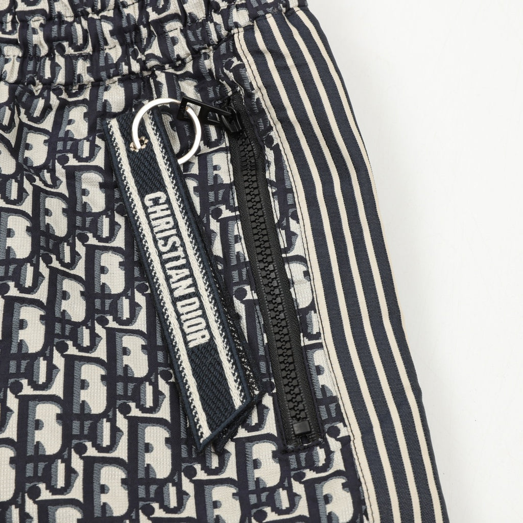 Pants close-up of drawstring and zipper pull with Dior monogram and striped trim