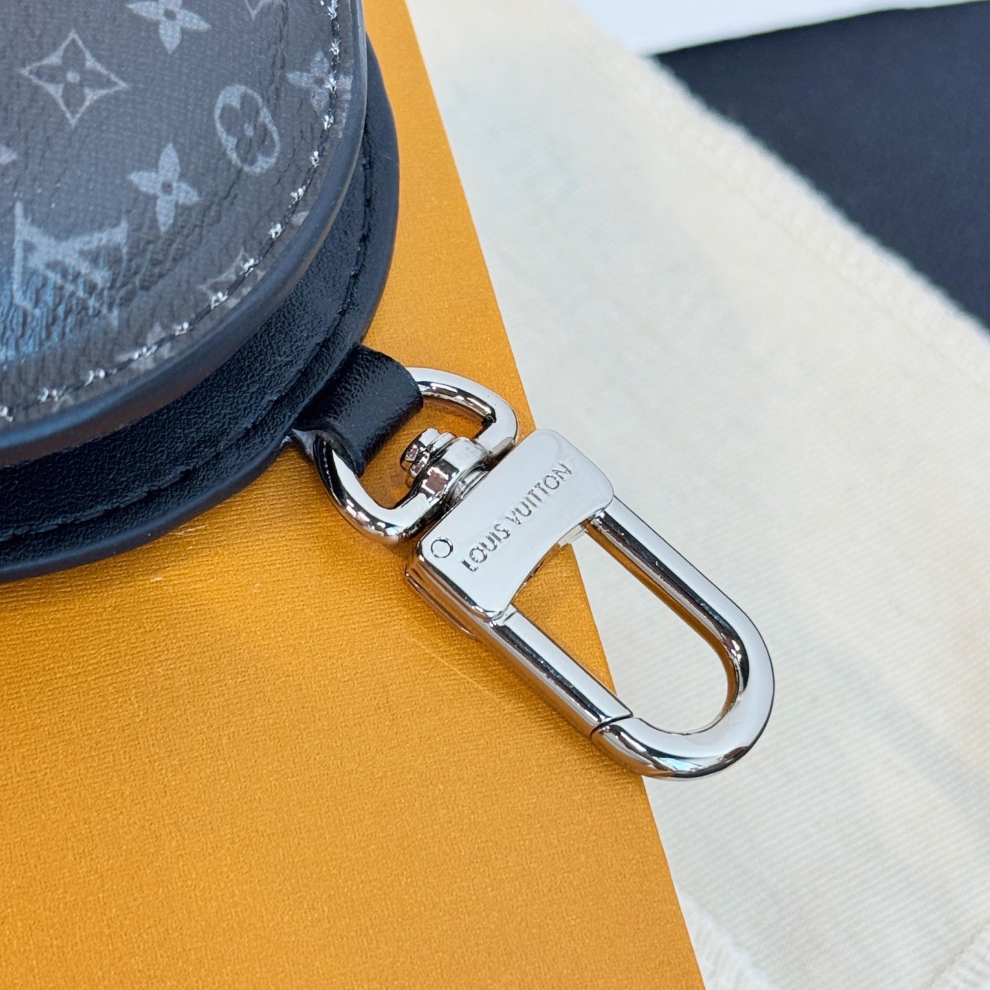 Louis Vuitton key fob clasp with engraved metal hook and leather pouch edge