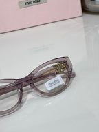 MiuMiu glasses close-up of round lenses and gold bridge with purple-toned frame
