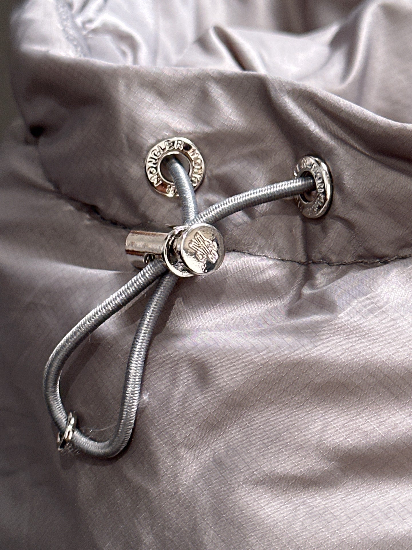 Gray jacket hood with drawstring and metal toggles detail