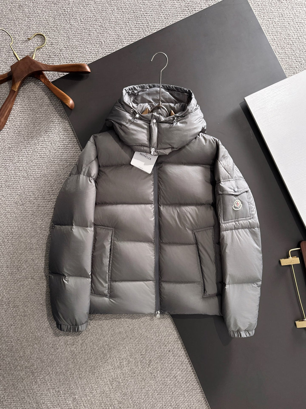 Gray hooded puffer jacket with full-length zipper and quilted front panels