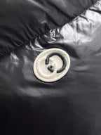 Gucci logo button patch on black padded jacket panel
