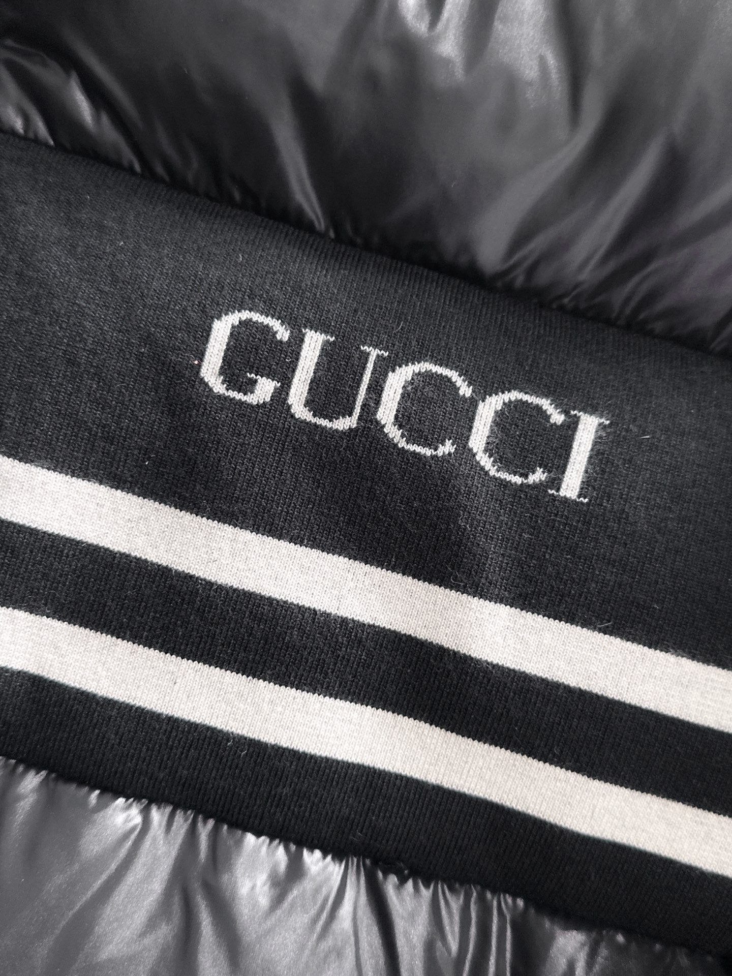 Gucci logo knit stripe on black padded jacket front