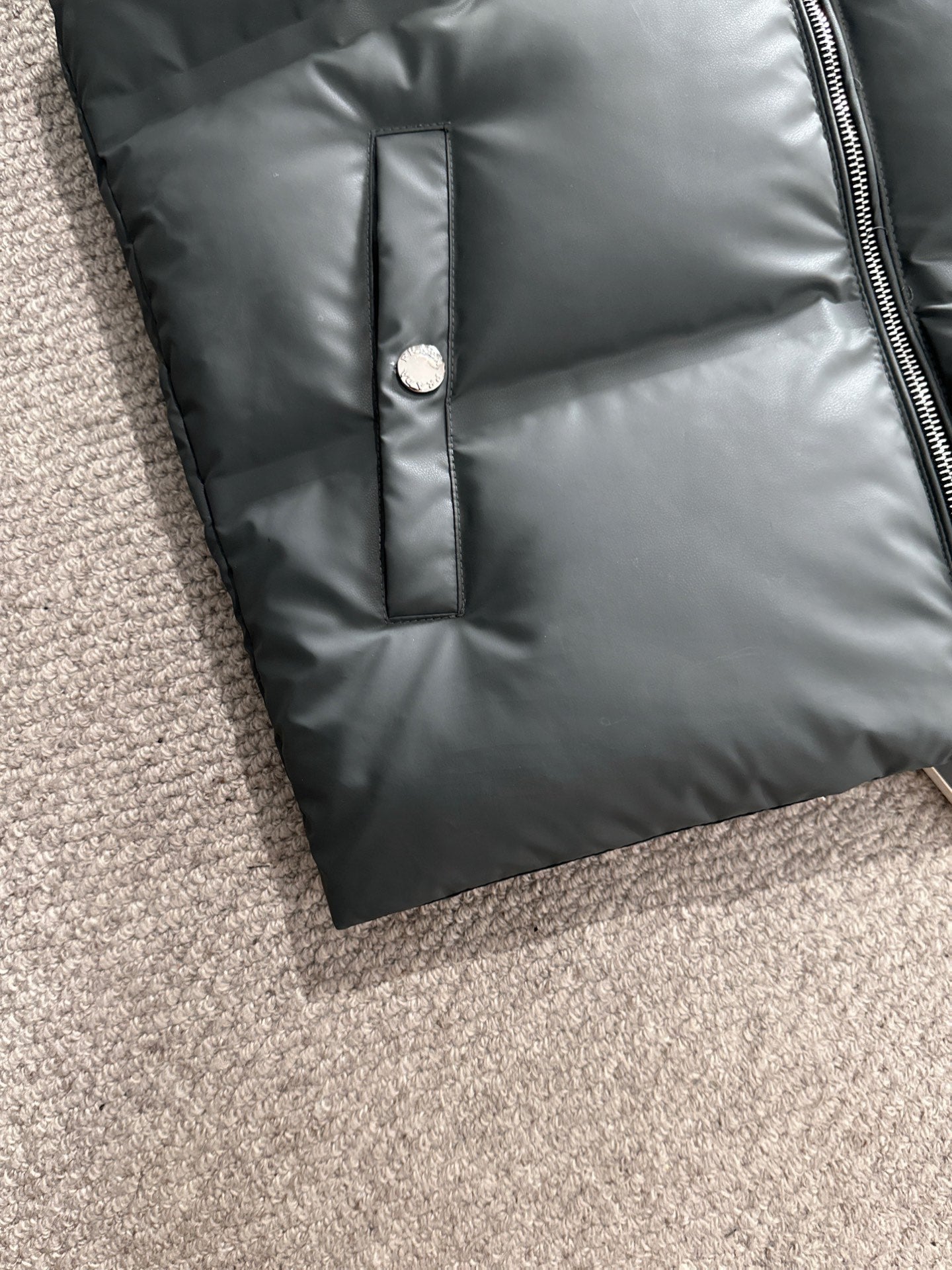 Dark gray puffer vest front panel with button placket detail