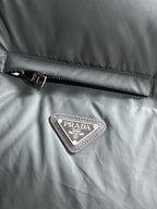 Prada triangular logo patch on dark gray quilted puffer vest fabric