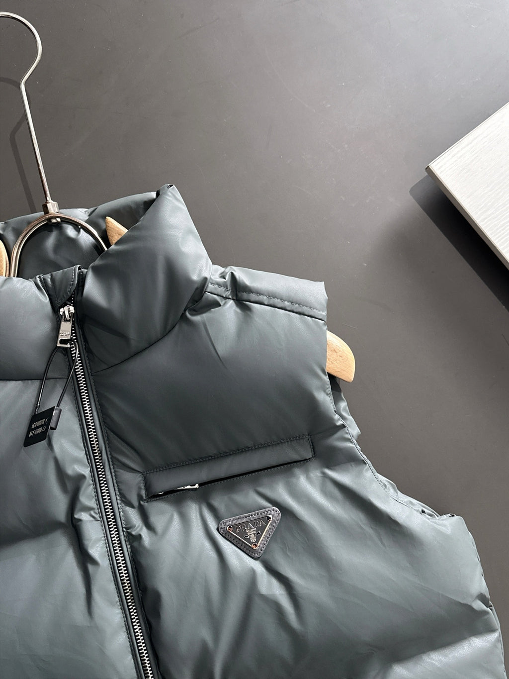 Dark gray puffer vest collar with front zipper and Prada triangular chest patch