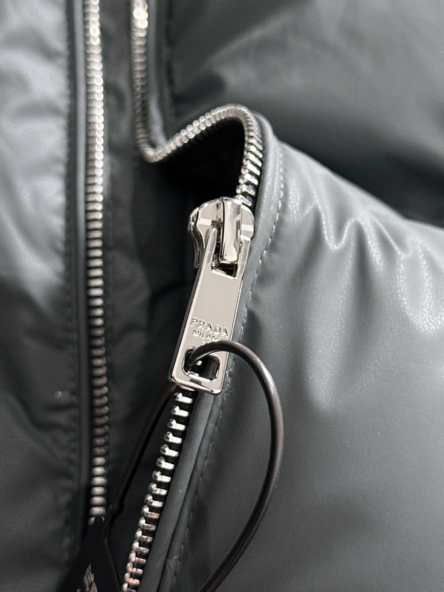 Dark gray puffer vest front zipper with metal pull and ring