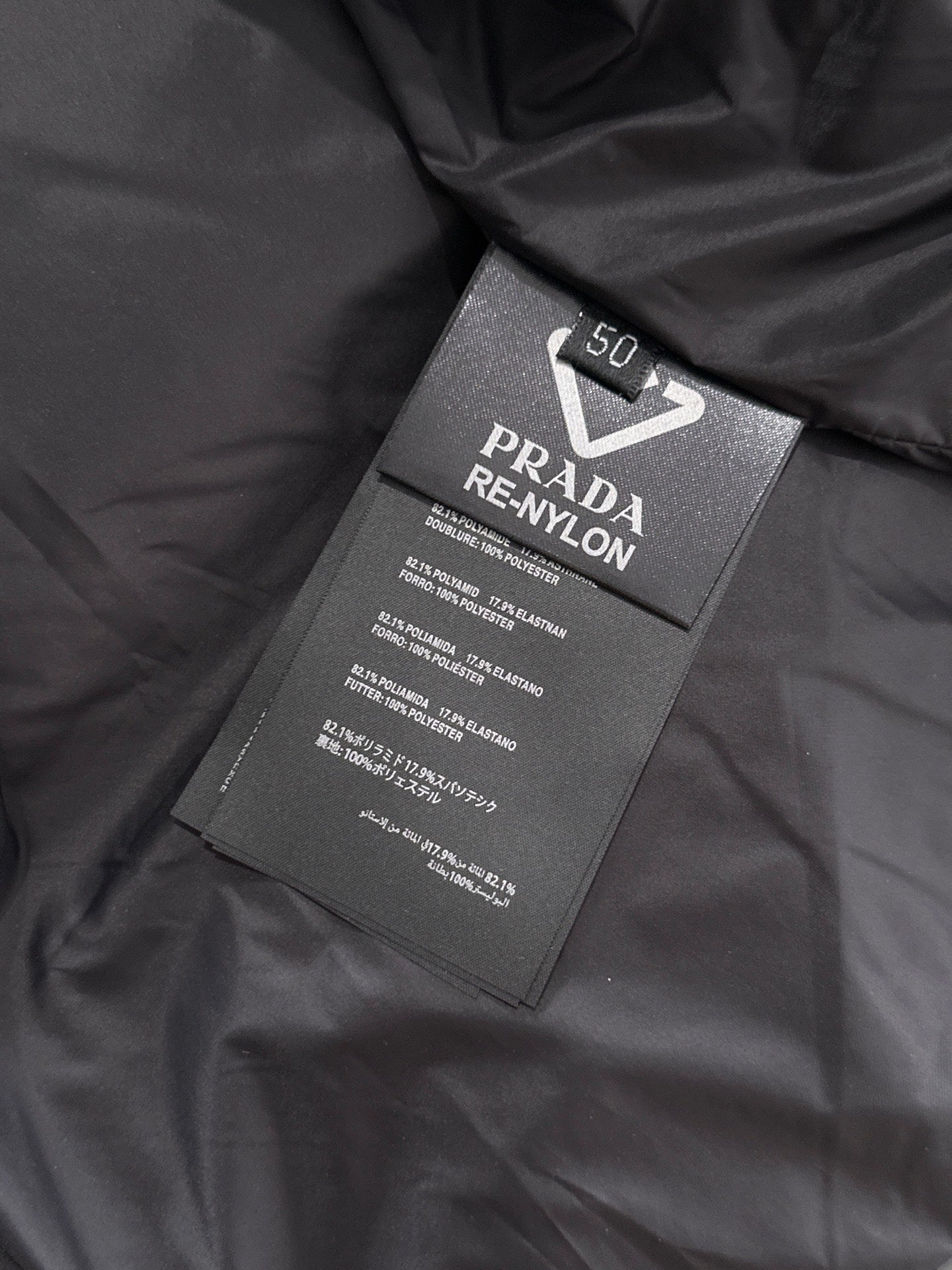 Prada RE-NYLON fabric label on black puffer vest