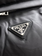 Prada triangle logo patch on black puffer vest fabric