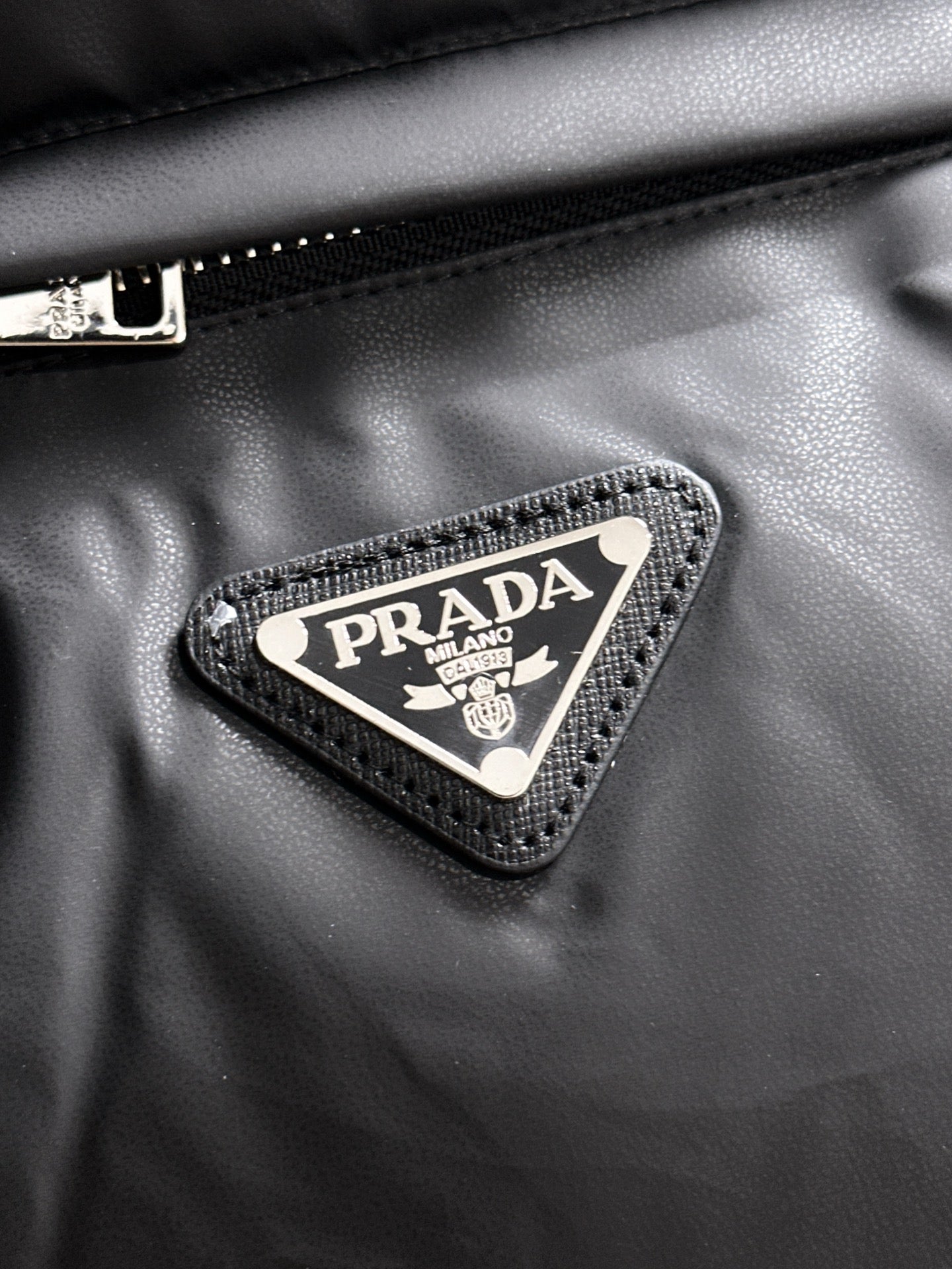 Prada triangle logo patch on black puffer vest fabric