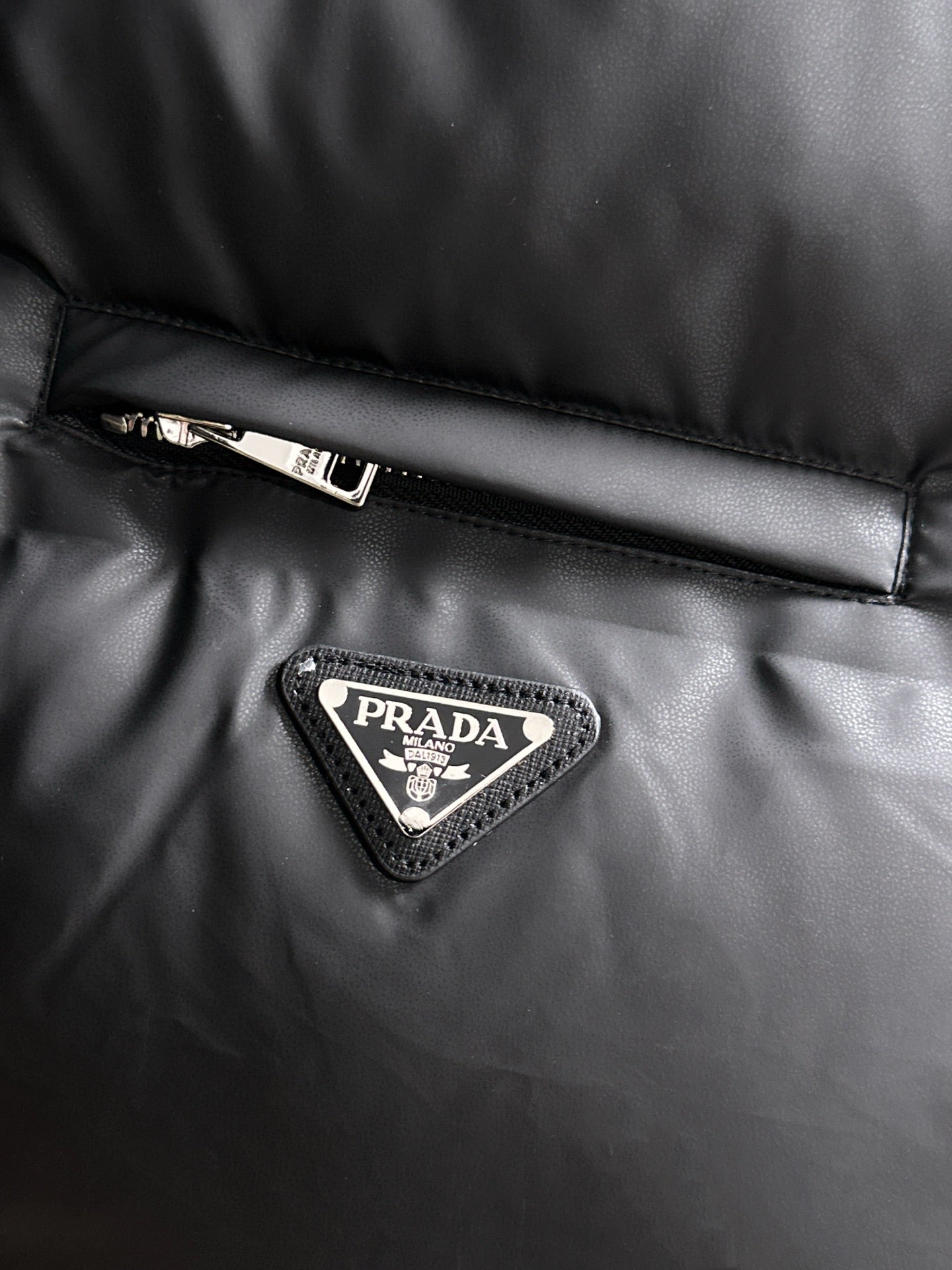 Prada logo patch on black puffer vest chest panel