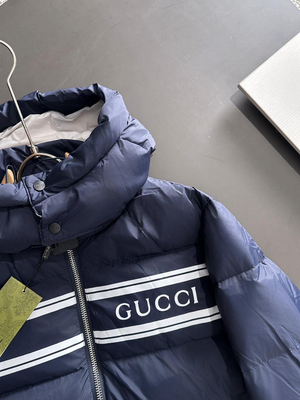 Gucci puffer jacket hood close-up, navy blue with logo patch and striped band