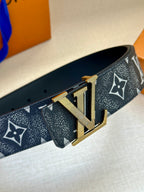 Monogram belt side view with gold-tone buckle on dark patterned strap