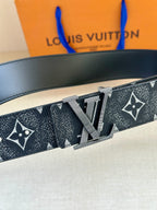 Monogram belt close-up with gold-tone buckle and dark patterned strap