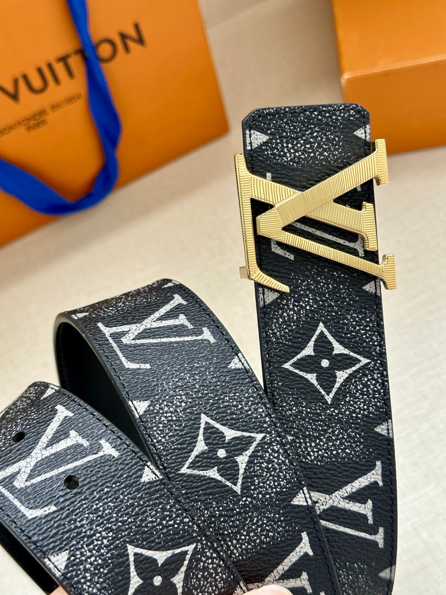 Louis Vuitton belt end and buckle close-up on dark monogram leather