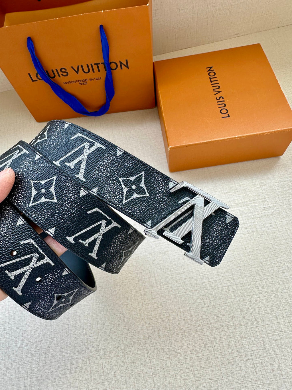 Louis Vuitton belt close-up with dark monogram leather and silver-tone buckle