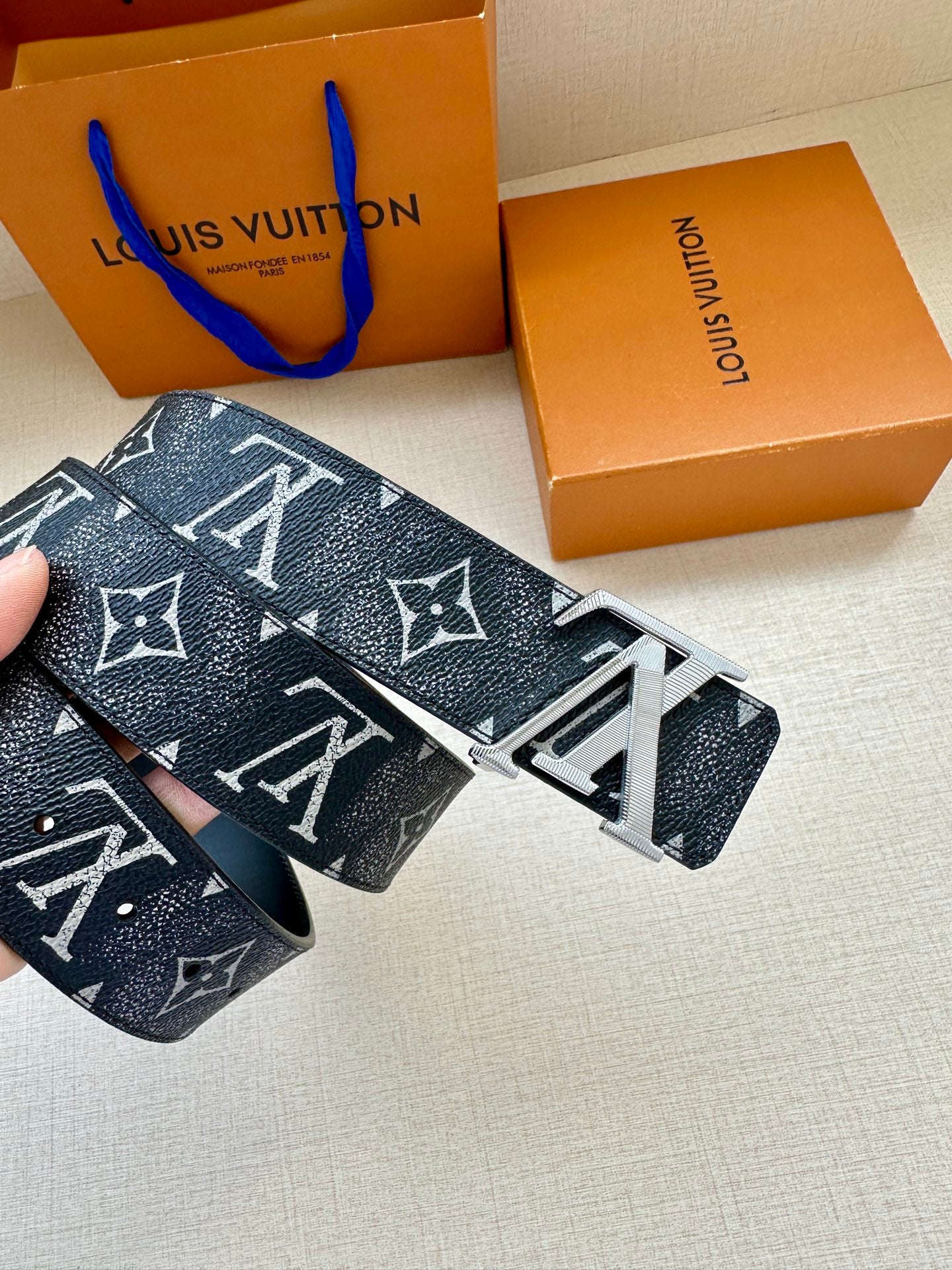 Louis Vuitton belt close-up with dark monogram leather and silver-tone buckle