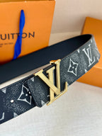 Louis Vuitton belt close-up with dark monogram strap and gold-tone LV buckle