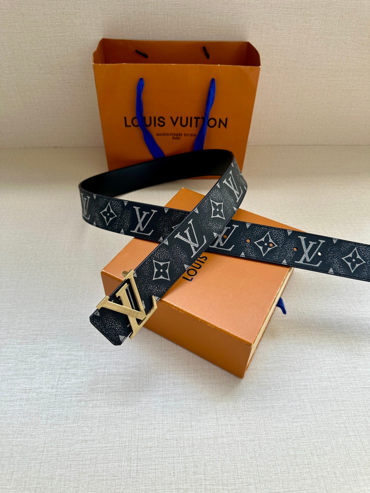 Louis Vuitton monogram belt with gold-tone buckle and dark patterned strap