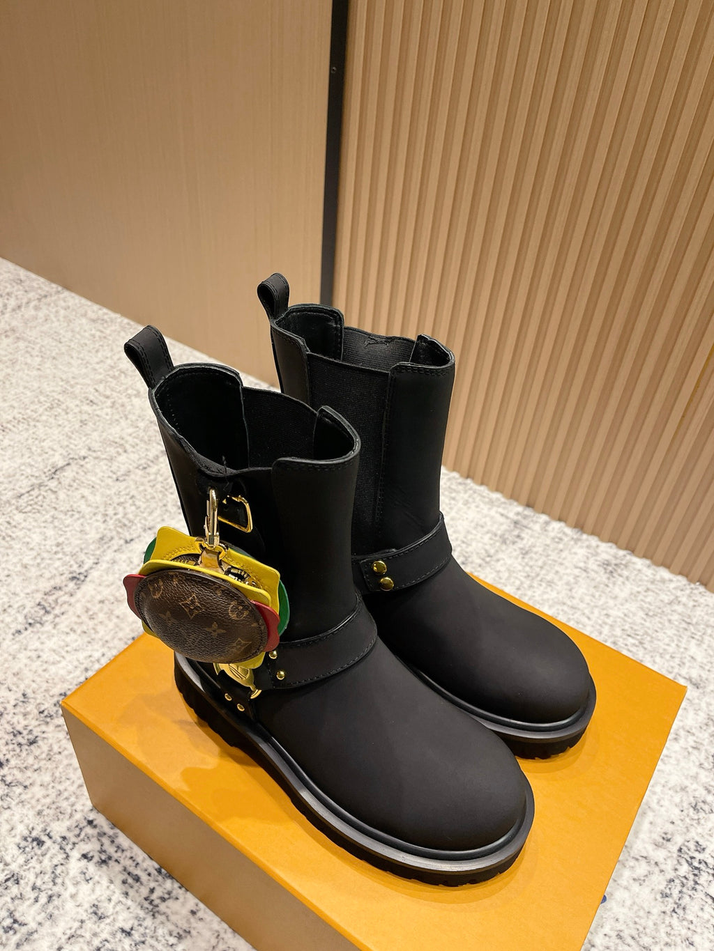 Louis Vuitton black ankle boots with gold strap hardware and circular charm, unisex
