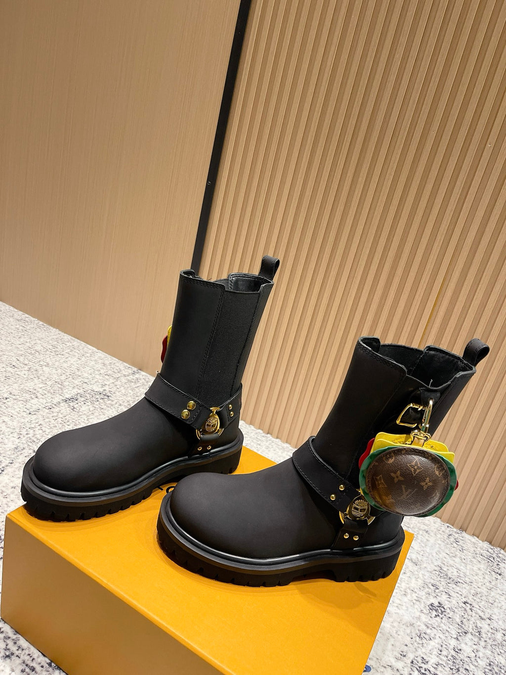 Louis Vuitton black ankle boots with gold strap hardware and round charm, unisex