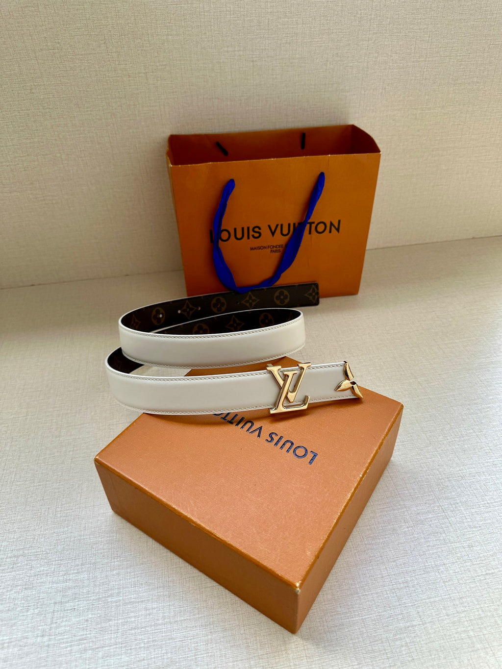 White leather belt with gold buckle and dark monogram band