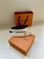 White leather belt with gold buckle and dark monogram band