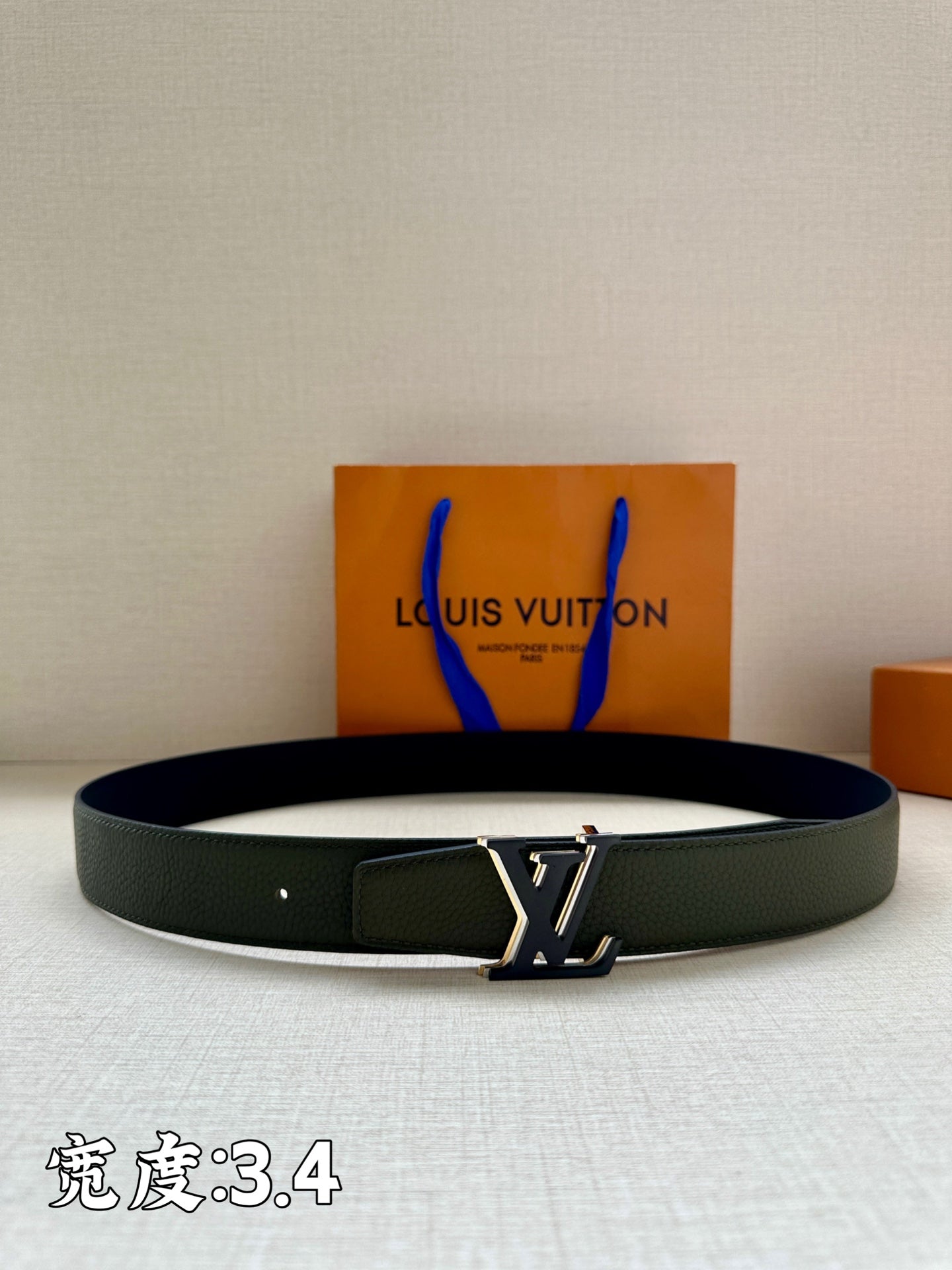 Louis Vuitton leather belt in dark green with silver LV buckle and keeper strap.