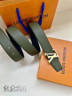 Louis Vuitton belt with dark green leather strap and silver LV buckle, laid out beside box.