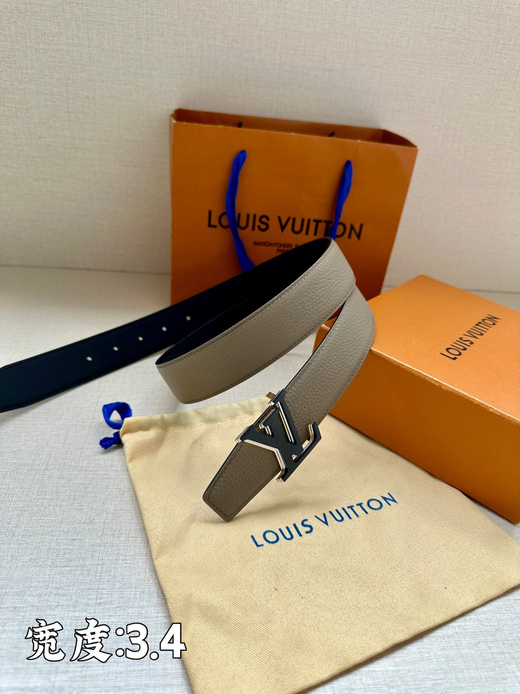 Grey leather belt with gold-tone LV buckle and perforated strap holes