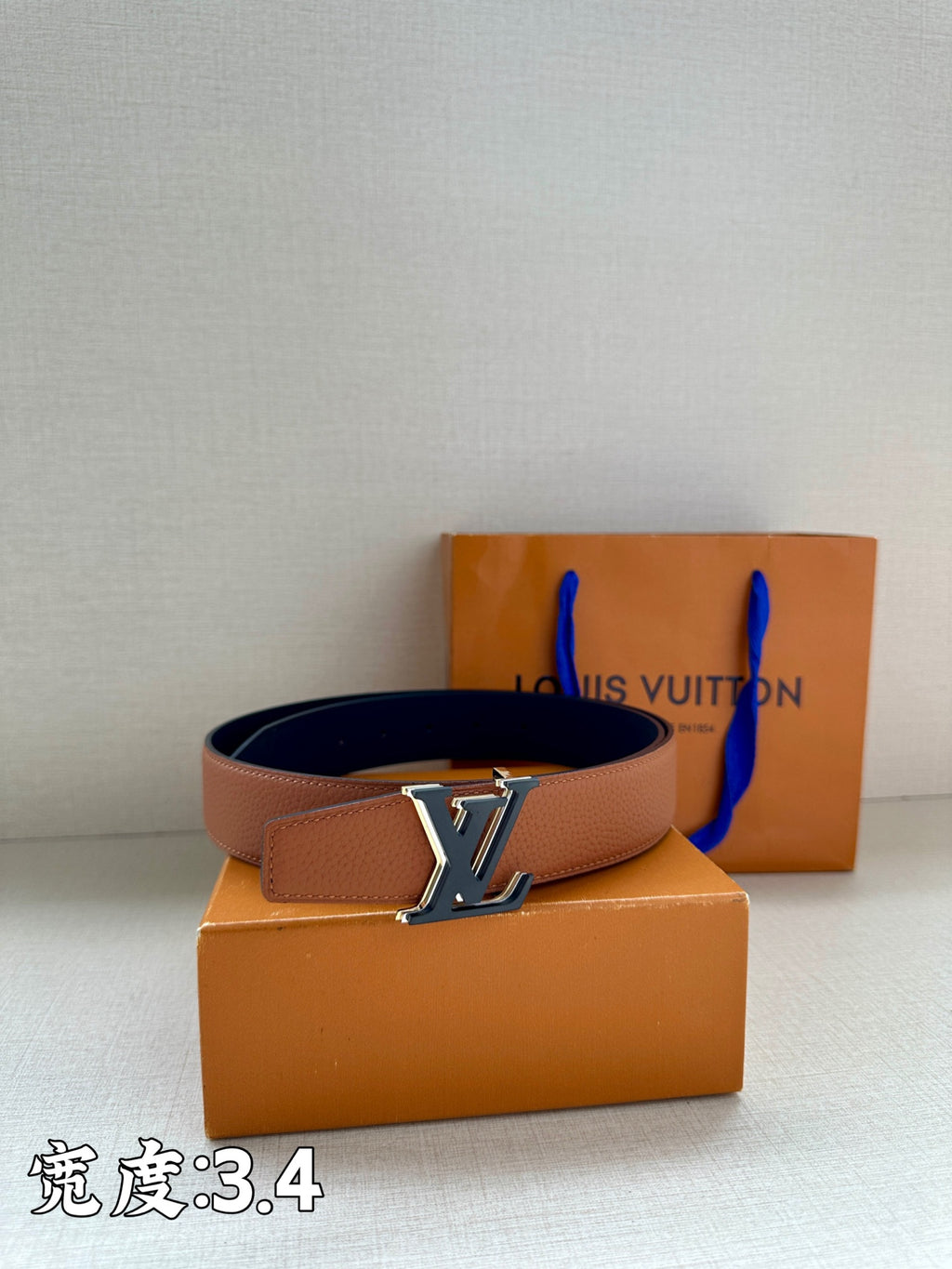 Brown leather belt with gold-tone LV buckle and black reverse side