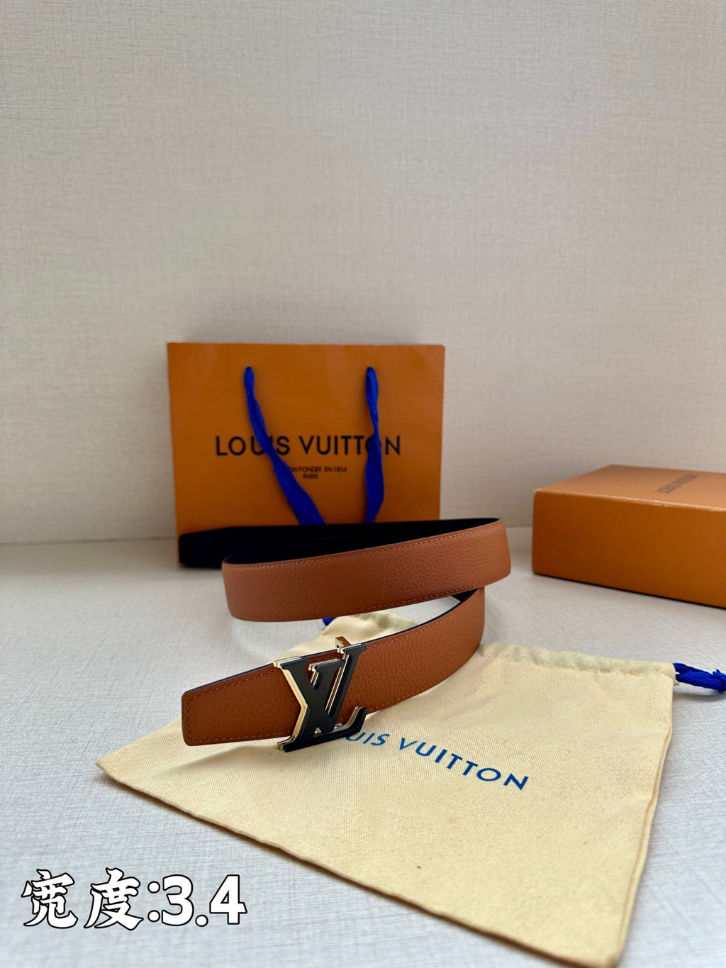 Brown leather belt with gold-tone LV buckle, laid coiled