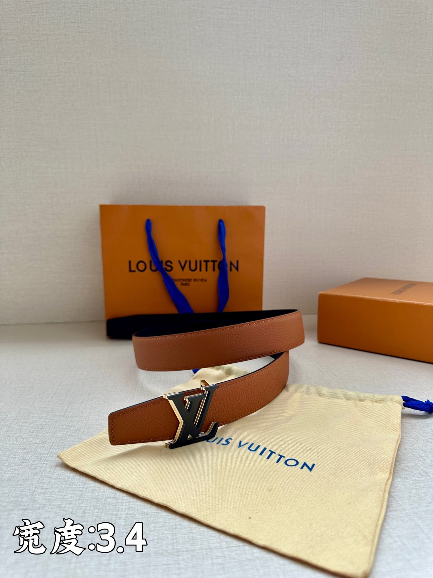 Brown leather belt with gold-tone LV buckle, laid coiled