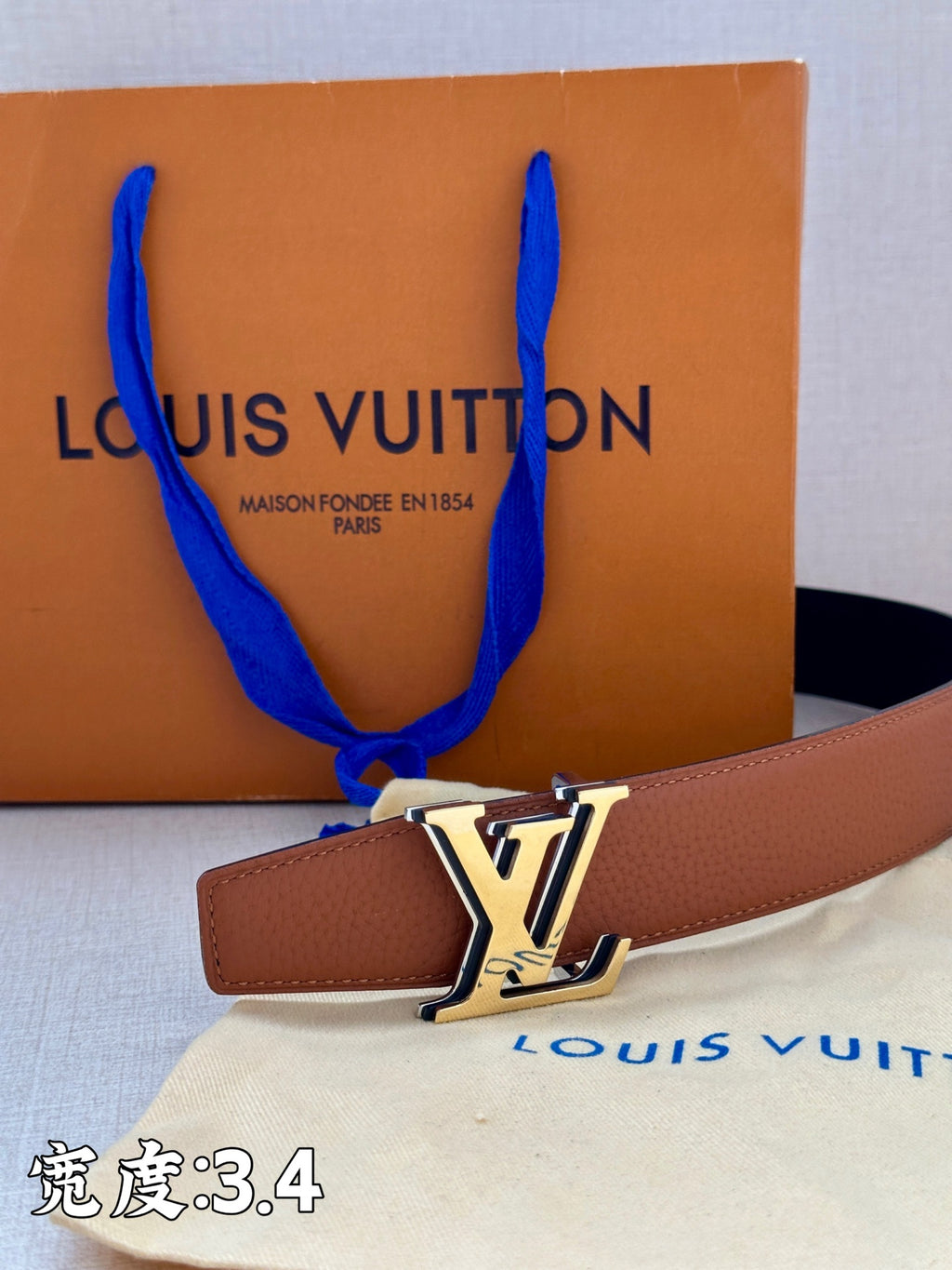 Brown leather belt with gold-tone LV buckle and tan strap tip